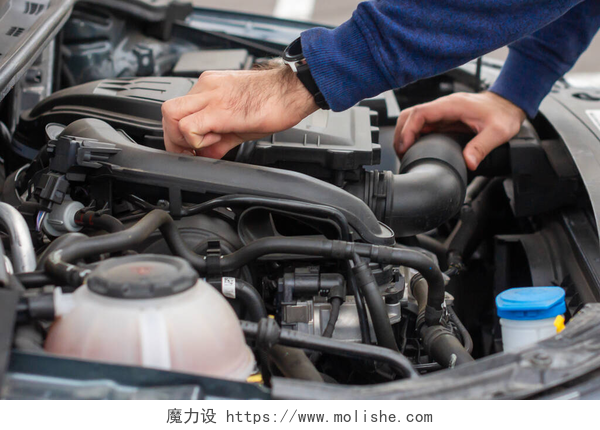 给汽车进行维修的维修工机械手的闭锁检查坏车篷下的电机.3.车辆概念的修理。汽车服务.